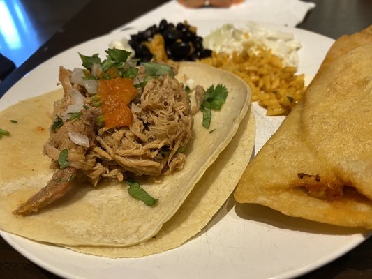 Pork taco with empanada and rice and beans