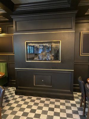 Black marble and brass fireplace detail with black paneling.