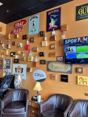 Comfy leather chairs and cigar boxes on the wall.