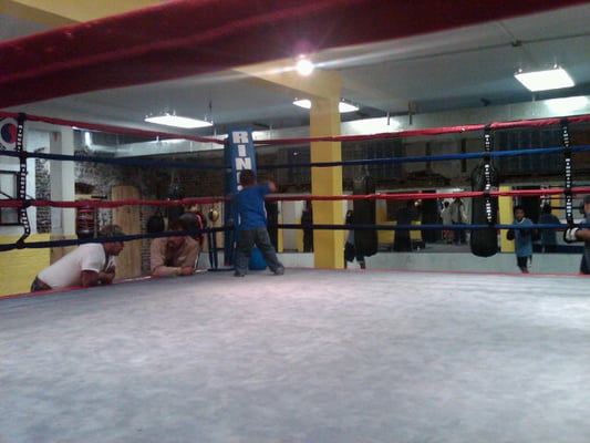 Two fathers catch up on the day's events while an aspiring boxer checks out the ring