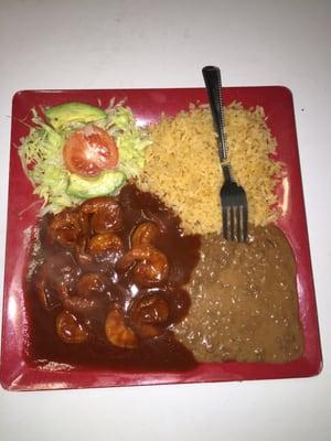 Camarones a la diabla spicy shrimp in a red mole sauce with rice and beans