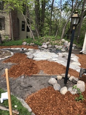 Installed rocks around light post, stone walkway and mulch all around it