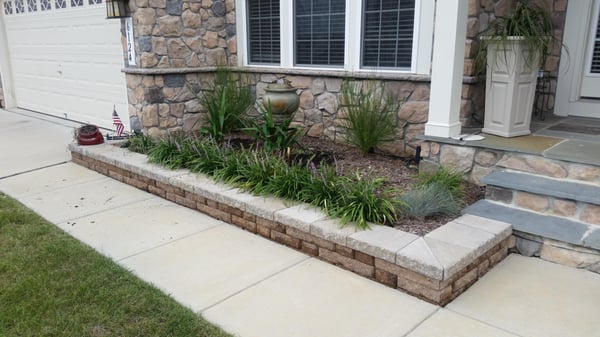 Nicolock wall with lirope and elephant yuccas. Water fountain accent. Landscape lighting installed as well.