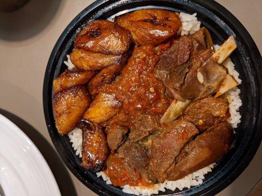 Stew with Got meat and fried plantains over rice