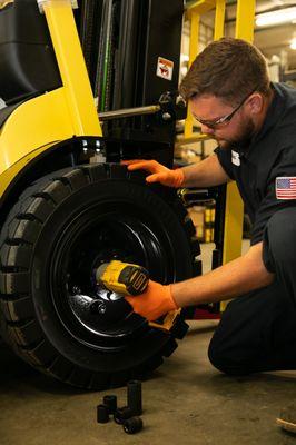 Service technician woking on a forklift tire