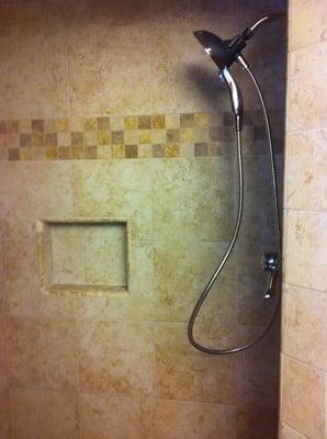 Custom tile shower with shampoo niche.