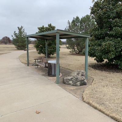 One of the many sitting areas with trash bins available on cement sidewalks.