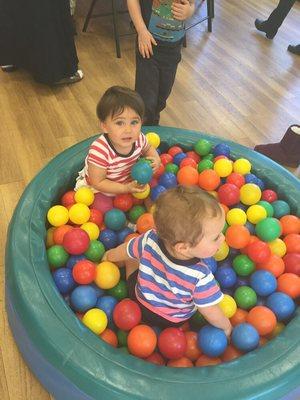 Social interaction in a plastic ball pit using core muscles, bilateral hand to grasp balls and cognitive skills.