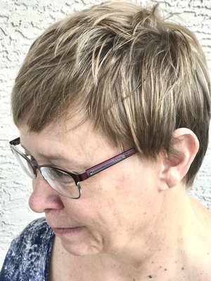 Sassy pixie with natural beige highlights designed to create a fullness in fine hair