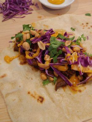 Korean BBQ Beef with peanuts, pear, sriracha mayo, shredded cabbage, cilantro, scallion.