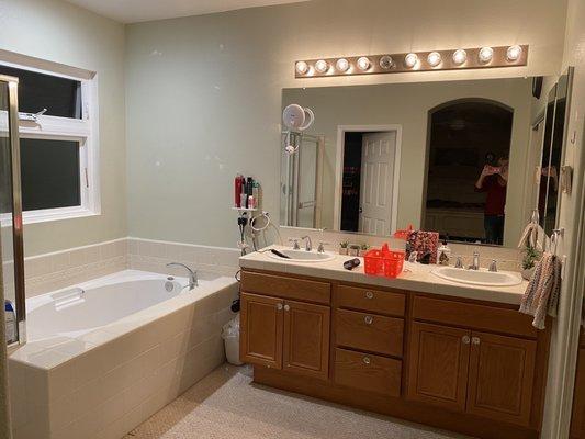 Original master bathroom, outdated lighting, carpet (?), hulking wood vanity