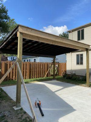 Back yard pad & car port, metal roof, designer sheeting, stained 1x12's in Luei of plain 4x8 sheets. Cool project!