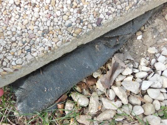 Landscape paper, which was actually serving a purpose to keep water away, thrown to the side. I shoved it under the tile so it wouldn't rock