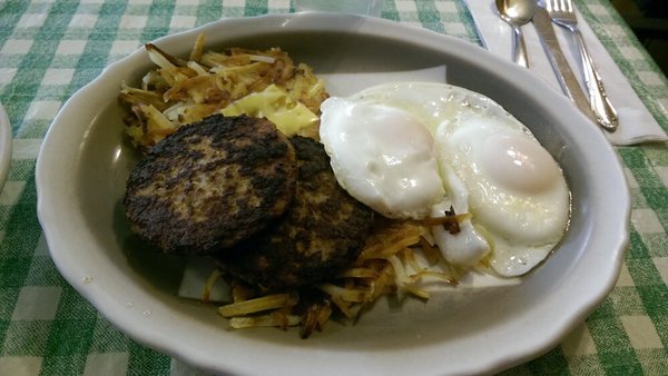 Sunny side up eggs are over cooked like everything on the plate, the sausage patties were murdered on the grill.