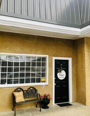 Front door and window of My Hearing Aid Place, with parking right out front of it.