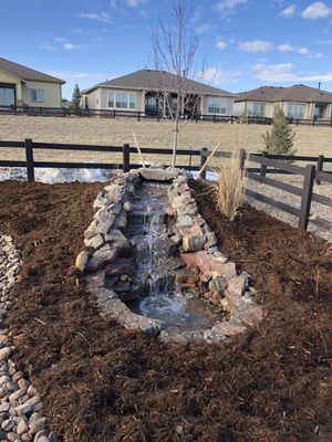 In one corner of the yard, we also created a water feature on top of a gradual berm (raised area) In Lone Tree CO