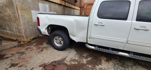 Damaged back door, post, truck bed, and wheelwell