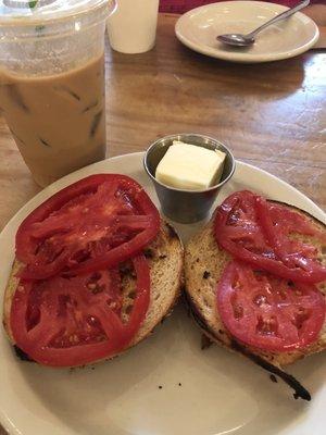 Toasted everything bagel with cream cheese and tomato slices. Latte