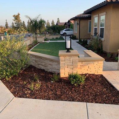 Planting, Lighting, Artificial Turf, Travertine, Stacked Stone,  and Custom Wall.