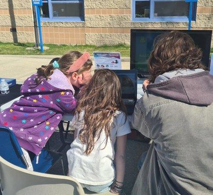 Code senseis in action at the 2022 Fitzgerald Elementary School Science Fair - teaching kids how to code a Maze in Scratch