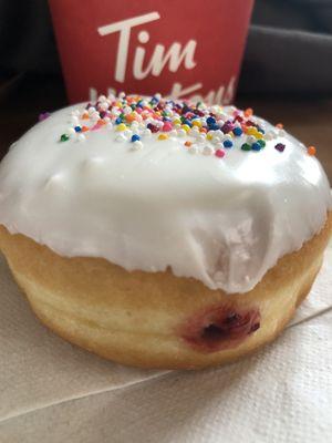 Raspberry filled doughnut with vanilla icing and sprinkles