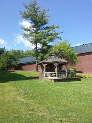 A gazebo (love those) stands between KOHS and their pool/gymnasium/auditorium.