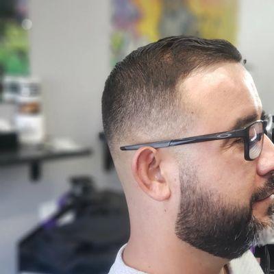 Mid skin fade with combover. Light trim on top with shears. Beard lined and tapered down from the razor fresh skin fade.