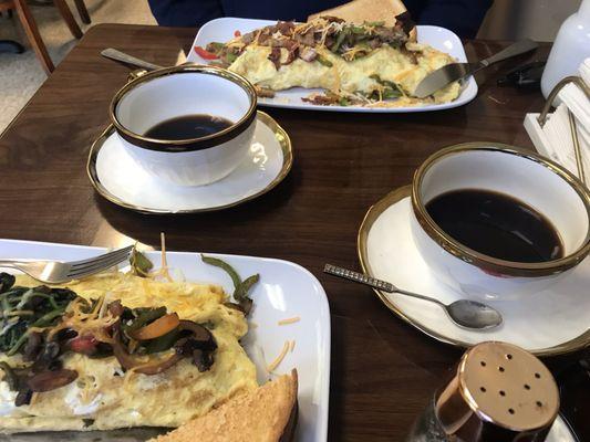 Veggie omelette and omelette supreme with bacon, sausage, red and green peppers, onions... with toast and a little side of salsa