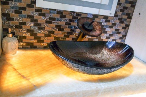 Renovated powder room with custom onyx counter top & under mount lighting!