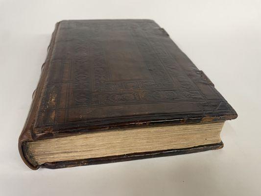 1568 binding with detached boards and split leather spine. Restored with new leather outer hinges to support original boards.