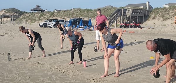 One arm rows on the beach.