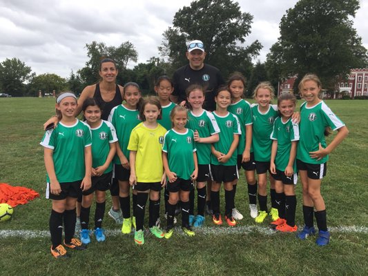 Former pro soccer player, Olympic medalist, and 1999 USWNT World Cup winner Sara Whalen stands with our Girls 2009 Strikers team.