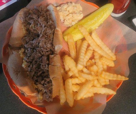 Philly cheesesteak with onions, fries and macaroni salad