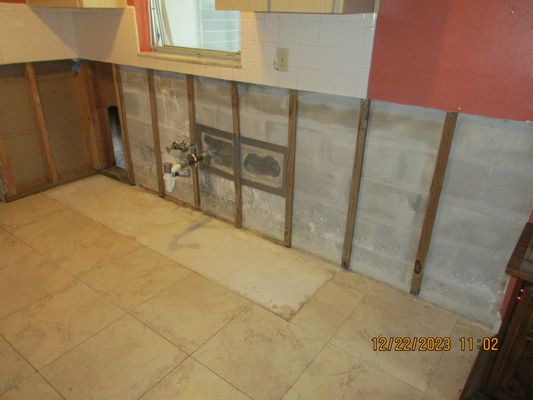 Water damaged cabinets removed, leaking pipe ready for plumber.