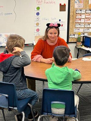 Speech-Language Pathologist helps two children in a group therapy session for speech therapy