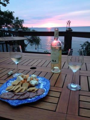 Sunset, lake, wine, and cheese plate.