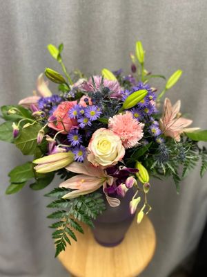 A lovely pink and purple bouquet, featuring roses, carnations, and lilies. Photo sourced from website.