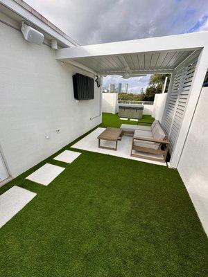 Rooftop- exterior limestone tile and premium synthetic grass.