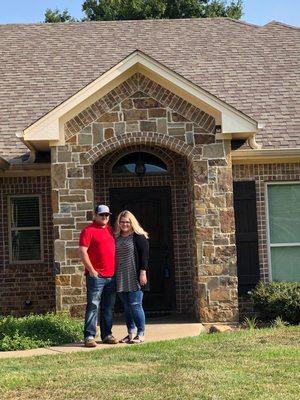 Sweet high school friends in front of their new home.