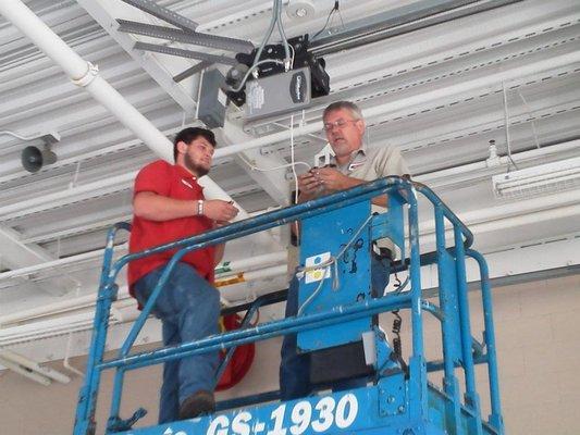 Jay and Michael installing some lights in a local firehouse garage.