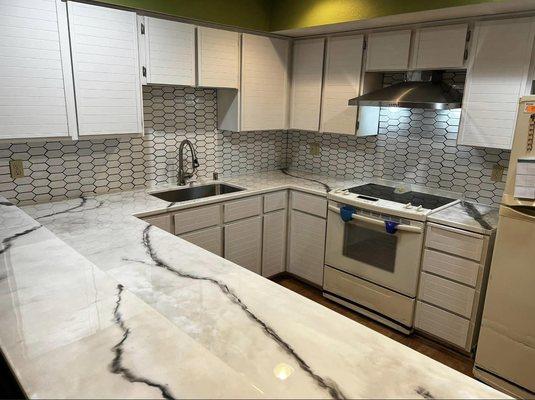 Kitchen remodel with epoxy countertops, backsplash, sink, and painted cabinets.