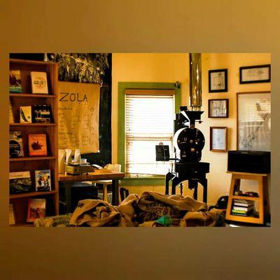 Zola main room and brewing station with bookshelf of books, bags of coffee beans.