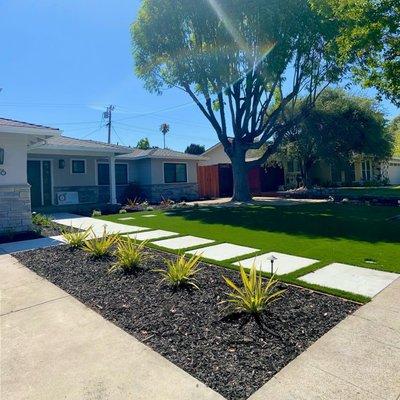 Transformed outdoor space with concrete paths, pavers, retaining walls, and turf