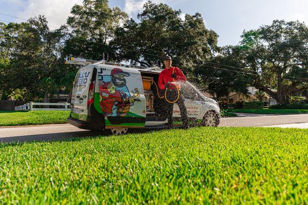 Technician treating lawn for pests.