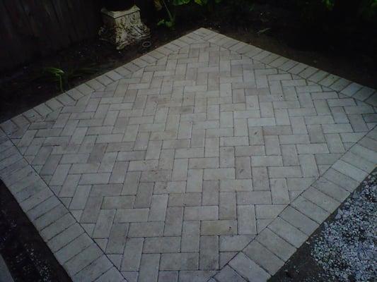 Small, square patio with a herringbone pattern.