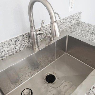 Single hole faucet with matching soap dispenser.