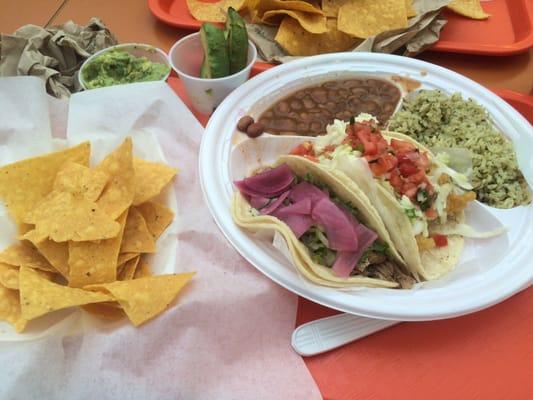 Pork Tacos with rice and beans, guac and chips.