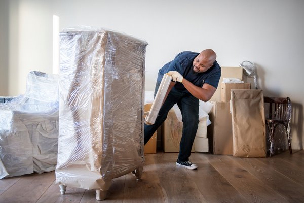 Mover unloading dresser from moving truck.