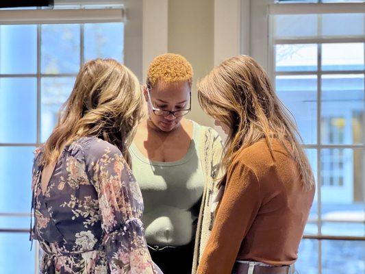 Gina Choi, Director of Spiritual Formation praying with ladies.