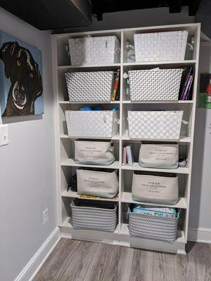 Wall mounted storage shelves in white with cute storage baskets.